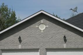 Round vent above garage doors with keystones
